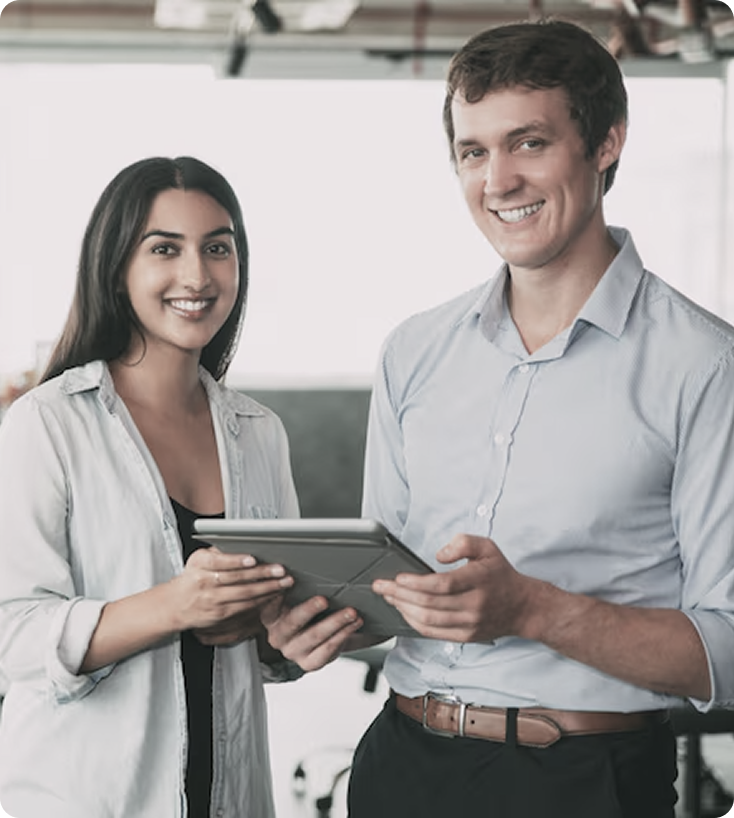 Smiling team members collaborating on a tablet, representing the synergy between a CTO, Product Manager, and Developer.